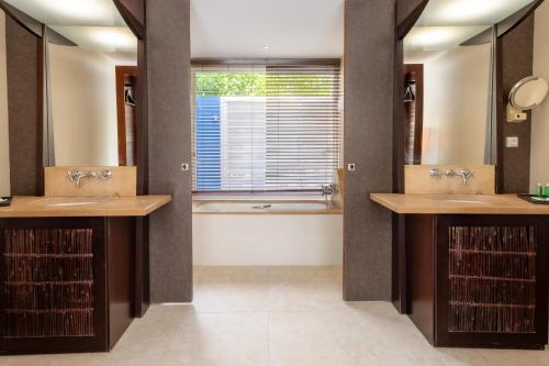 ein Badezimmer mit 2 Waschbecken und einer Badewanne in der Unterkunft Villa Physacap in Le François