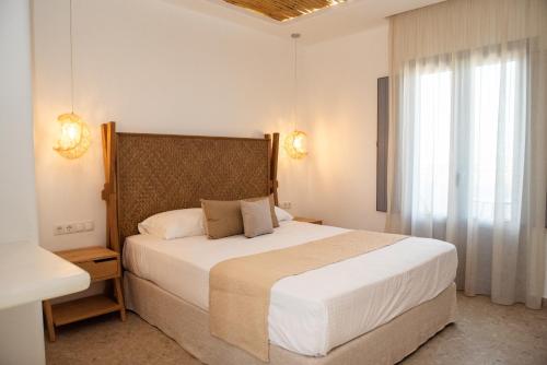 a bedroom with a large bed and a window at Anais Of Naxos in Agia Anna Naxos