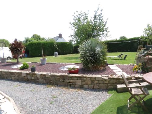 einen Garten mit einer Schutzwand und einigen Pflanzen in der Unterkunft chambre d'hôte naturiste ou pas in Miniac-Morvan