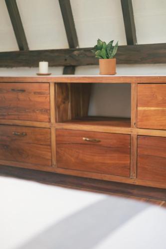 a wooden dresser with a potted plant on it at Nahouse Jungle Lodges in Tulum