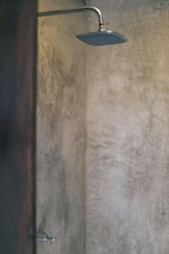 a shower with a light hanging from a wall at Nahouse Jungle Lodges in Tulum