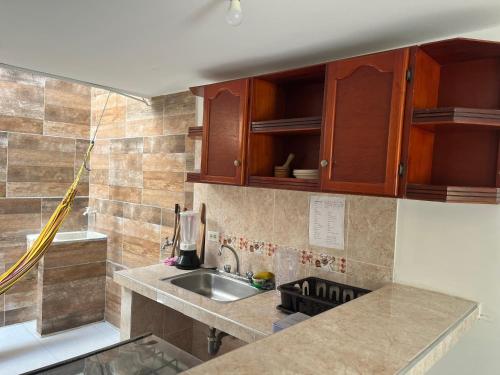 a kitchen with a sink and wooden cabinets at Casa - chalet Cartagena in Cartagena de Indias