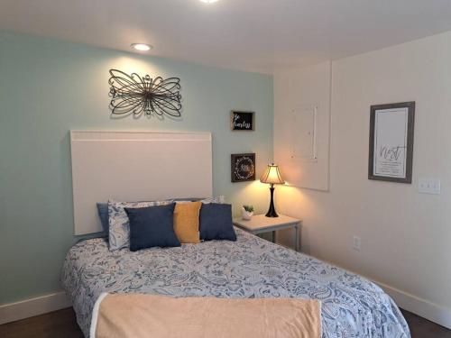 a bedroom with a large bed with blue pillows at The Cottage at Moore House in Florence