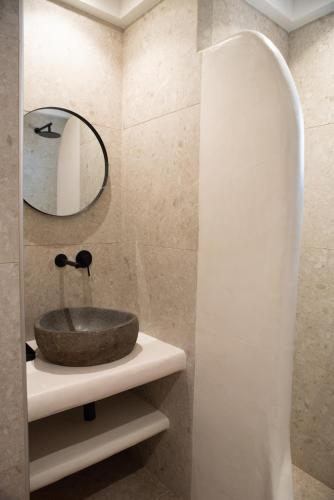 a bathroom with a stone sink and a mirror at Anais Of Naxos in Agia Anna Naxos