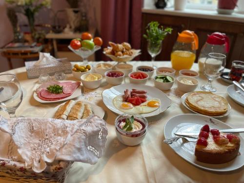 a table with plates of breakfast food on it at My Home Guest House in Baku