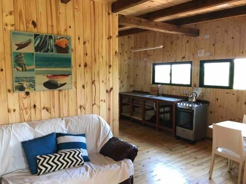 Chacra Celeste: montañas y mar في بيريابوليس: غرفة معيشة مع أريكة بيضاء وطاولة