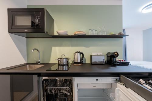a kitchen with a sink and a microwave at Nena Apartments Berlin Adlershof in Berlin