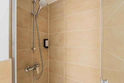 a shower with a shower head in a bathroom at Nena Apartments Berlin Adlershof in Berlin