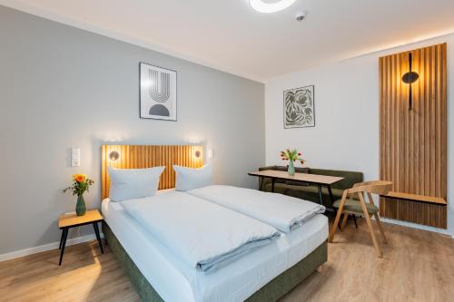 a bedroom with a large bed and a desk at Nena Apartments Berlin Adlershof in Berlin
