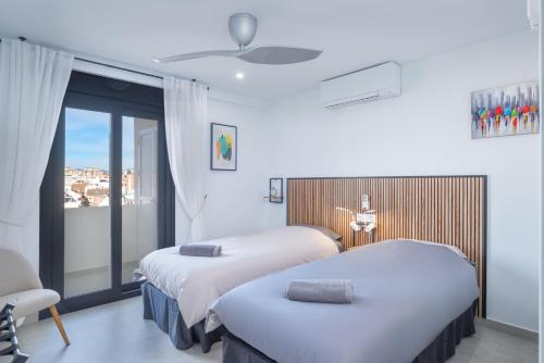a hotel room with two beds and a balcony at Appartement PM 25 in Fuengirola