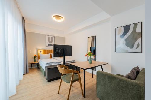 a living room with a table and a bed at Nena Apartments Berlin Adlershof in Berlin