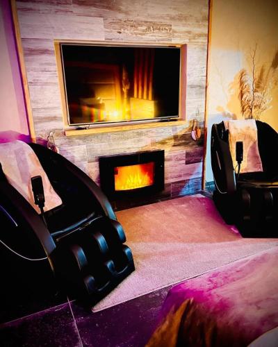 sala de estar con chimenea y 2 sillas frente a ella en Suite luxe l'Infini, en Istres