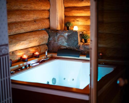 bañera en una habitación con pared de piedra en Metsapiiga Puhkemaja, 