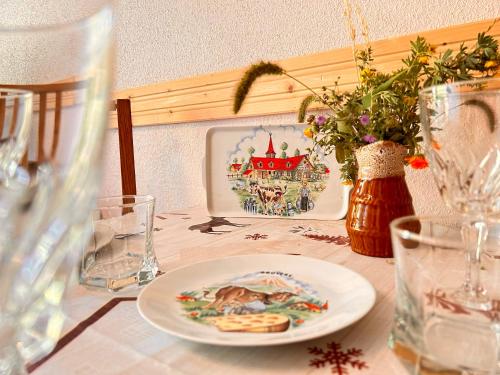 a table with a plate of food and glasses on it at Carla's Residences - Le Margériaz in Aillon-le-Jeune