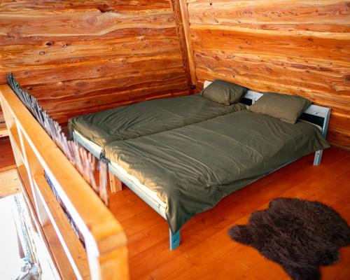 Cama en habitación con pared de madera en Metsapiiga Puhkemaja, 