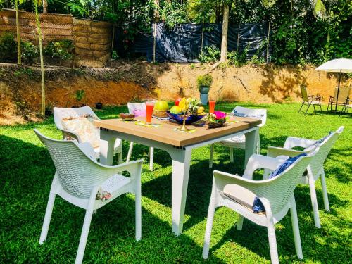 una mesa con sillas y un bol de fruta en ella en Queen's Villa, en Habaraduwa Central