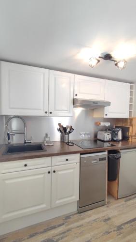 une cuisine avec des armoires blanches et un évier dans l'établissement La Caravelle - À 5 min de Cassis, à Roquefort-la-Bédoule