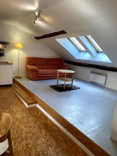 uma sala de estar com um sofá e uma mesa em Studio Orgelet-Lac de Vouglans em Orgelet