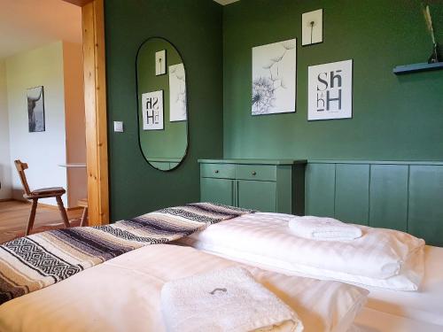 Un dormitorio con una cama con paredes verdes y espejos en Gruberwirt Apartment mit 1 Schlafzimmer GW 5, en Innsbruck