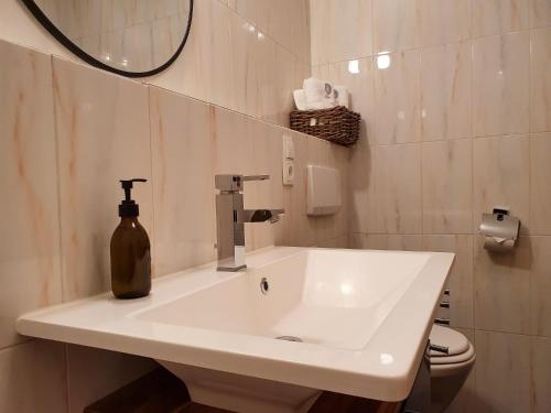 a white bathroom with a sink and a mirror at Gruberwirt Apartment mit Blick auf die Berge GW 7 in Innsbruck