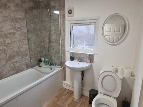 La salle de bains est pourvue de toilettes, d'un lavabo et d'une douche. dans l'établissement Whitby Elegance Free Parking, Close to Metro and Bus Station, à Tynemouth