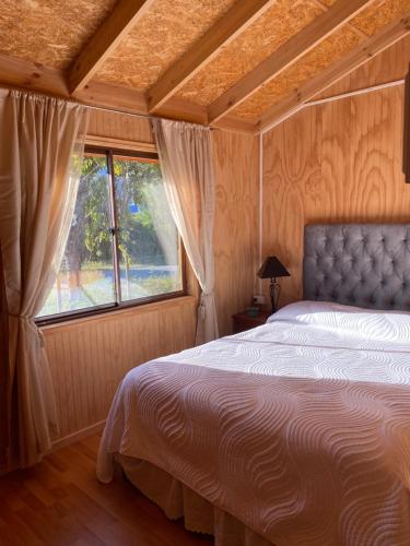 a bedroom with a bed and a large window at Cabañas La Plaza in Bahía Murta