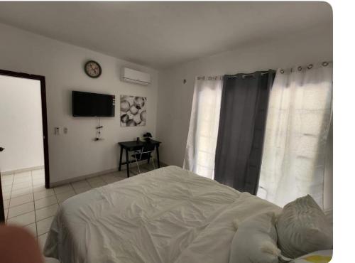 a bedroom with a bed and a tv on a wall at Villas L'Hostalet in San Pedro Sula