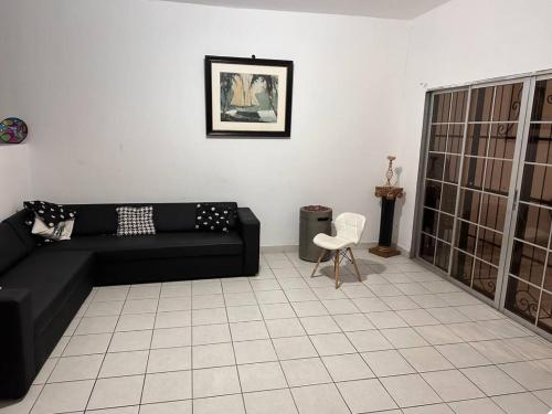 a living room with a black couch and a chair at Villas L'Hostalet in San Pedro Sula