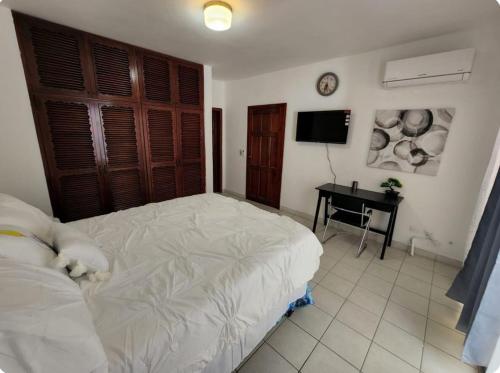 a bedroom with a white bed and a desk at Villas L'Hostalet in San Pedro Sula