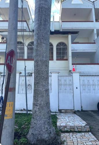 a stop sign next to a palm tree in front of a house at Villas L'Hostalet in San Pedro Sula