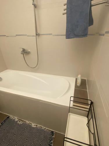 a white bath tub in a bathroom with a shower at appartement agréable tout confort Entièrement Meublé in Aubervilliers