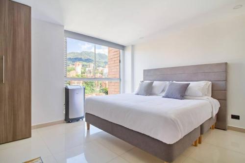 um quarto com uma cama grande e uma janela em Stylish Estudio La Frontera em Medellín