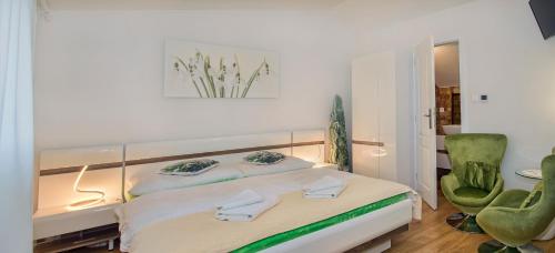 um quarto com uma cama e uma cadeira verde em VeLa em Malý Slavkov