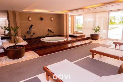 una sala de estar con jacuzzi en el medio en Qavi - Flat Resort Beira Mar Cotovelo #InMare133, en Parnamirim