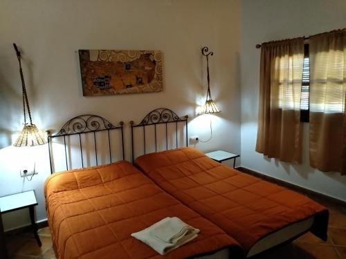 - une chambre avec un lit et une couverture orange dans l'établissement CASA RURAL LA CABRA DEL MEDIO, à Monesterio