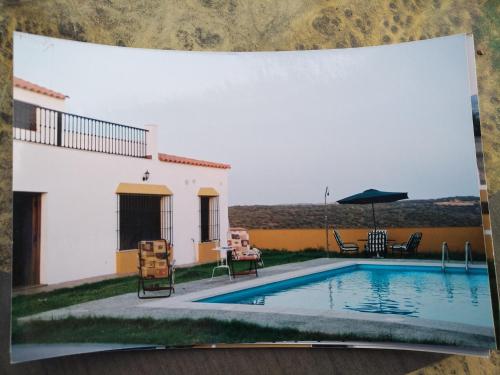 a picture of a house and a swimming pool at CASA RURAL LA CABRA DEL MEDIO in Monesterio