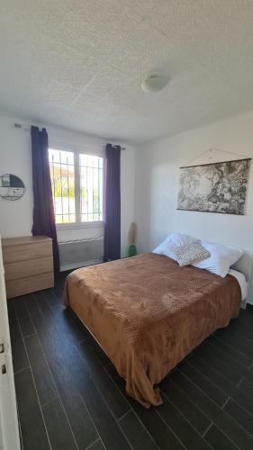 ein Schlafzimmer mit einem großen Bett und zwei Fenstern in der Unterkunft Cocon douillet de Mélanie in Marignane