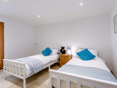 two beds in a room with blue pillows at 2 Bed in Lympstone 80586 in Lympstone