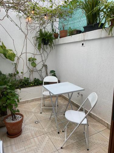 a table and two chairs on a patio with plants at Morada City Hostel in Sao Paulo