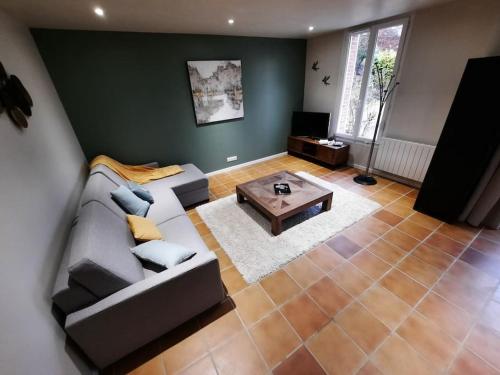 un salon avec un canapé et une table basse dans l'établissement La Jouvencière ***, à Jouy