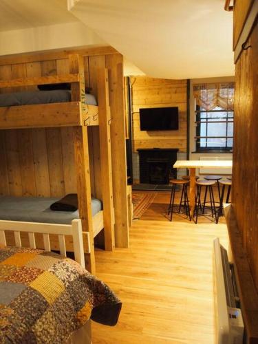 a bedroom with bunk beds and a living room with a table at The Snug in Matlock