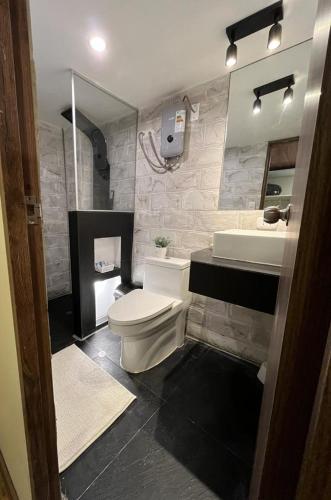 a bathroom with a white toilet and a sink at Casa Virgen del Carmen in Cusco