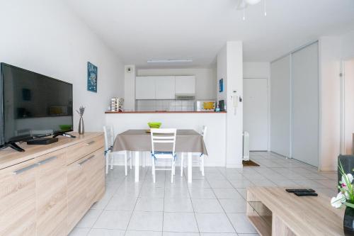 Il comprend une cuisine et une salle à manger avec une table et une télévision. dans l'établissement Les clés de Jonzacconciergerie Carré des Antilles, à Jonzac