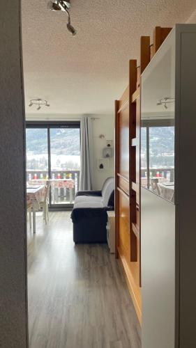 une chambre avec un lit, une table et des fenêtres dans l'établissement La Méa, à Barcelonnette