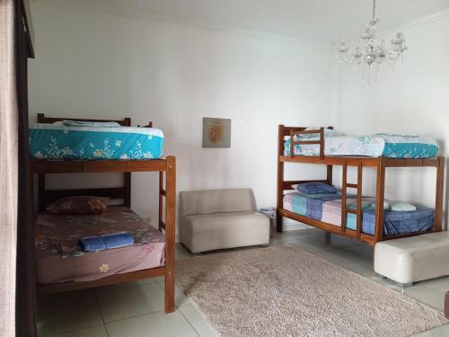 a room with two bunk beds and a chair at Guajira Hostel SCZ in Santa Cruz de la Sierra