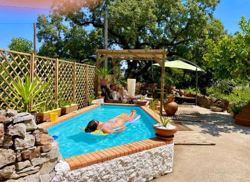 una mujer tendida en una piscina en un patio trasero en Wellness guesthouse Casa é Connosco, en Alvaiázere