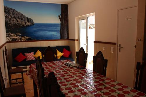 a dining room with a table and a painting of the ocean at Racing Mackerel Hostel in Lagos