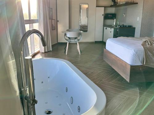 a bathroom with a bath tub next to a bed at Villa Marbella by Potenza Rentals in Santo Domingo