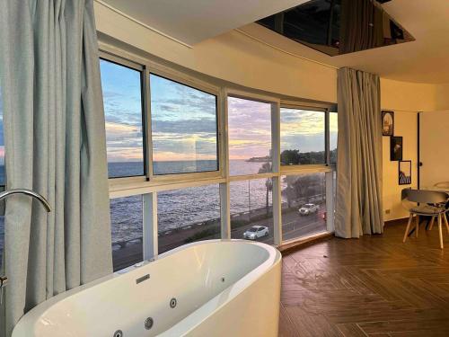 a bath tub in a room with large windows at Villa Marbella by Potenza Rentals in Santo Domingo