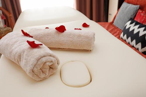 a white table with towels and a mirror and roses at Athenee Calea Victoriei Apartment in Bucharest